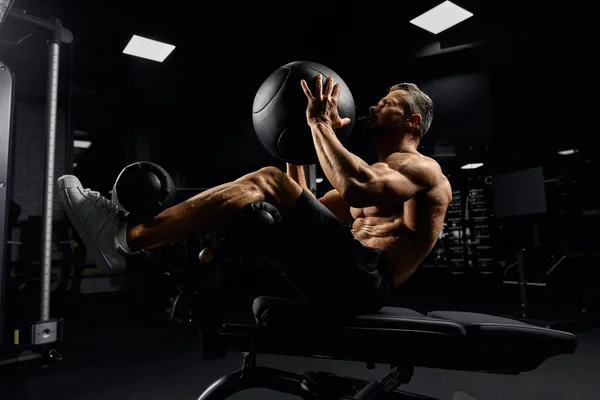 Man building core nuscles with ball on bench. — 스톡 사진