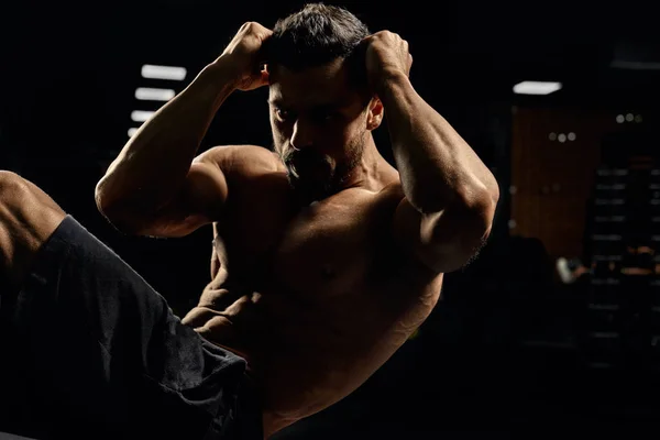 Man doing diagonal crunches in gym. — Stockfoto