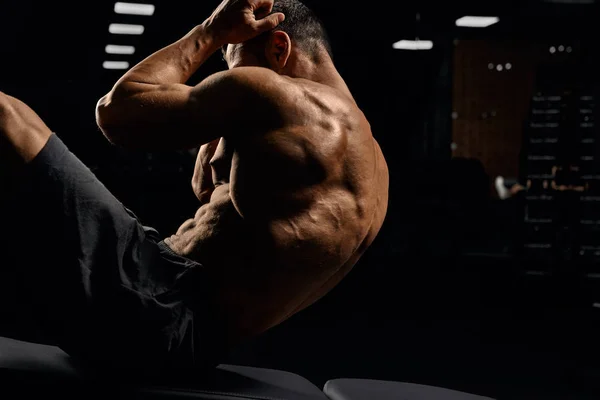Mann bygger muskler på matte. – stockfoto