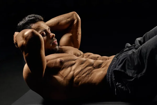 Hombre construyendo los músculos del núcleo en la estera. — Foto de Stock