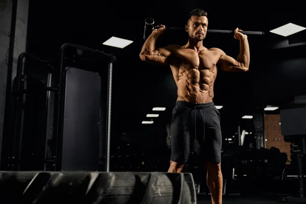 Musculoso hombre sosteniendo mazo detrás del cuello. — Foto de Stock