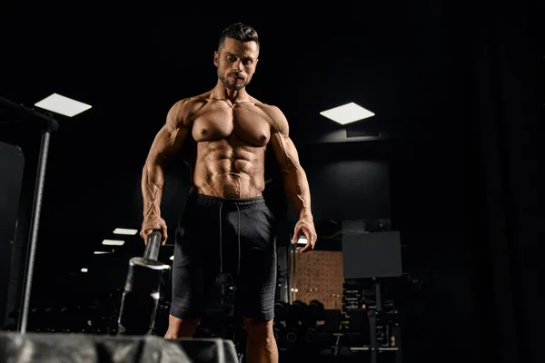 Muscular sportsman carrying sledgehammer in gym. — Stockfoto