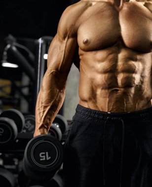 Male bodybuilder holding dumbbell.