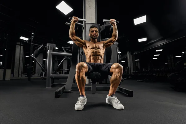 Male bodybuilder training on simulator. — Stock Photo, Image