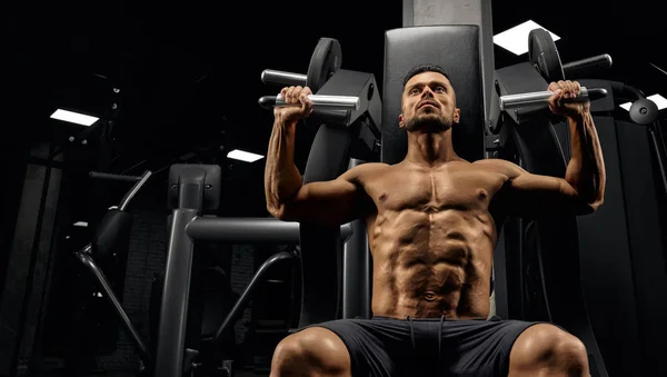 Shirtless bodybuilder training back on simulator. — Stock Photo, Image