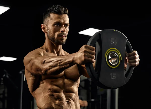Bodybuilder holding weights straight out. — Stockfoto