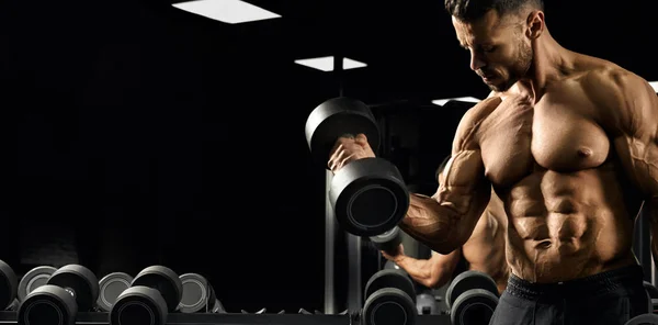 Muscular bodybuilder training biceps in gym. — Stok fotoğraf