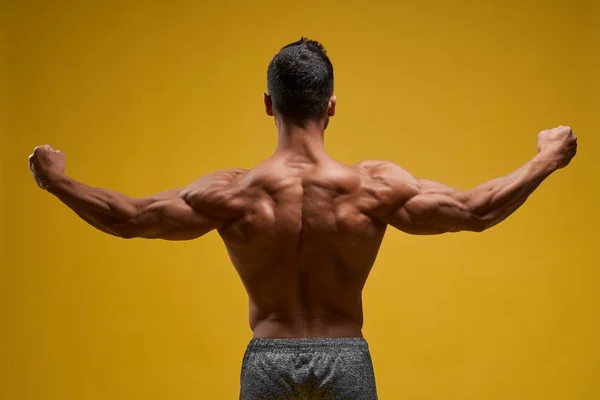 Muscular jovem mostrando bíceps perfeito — Fotografia de Stock