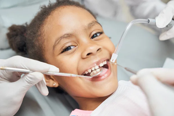 Linda chica africana durante el tratamiento dental en la clínica moderna —  Fotos de Stock