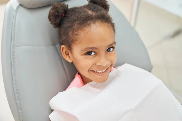 Charmig afro flicka väntar på tandvård på kliniken — Stockfoto