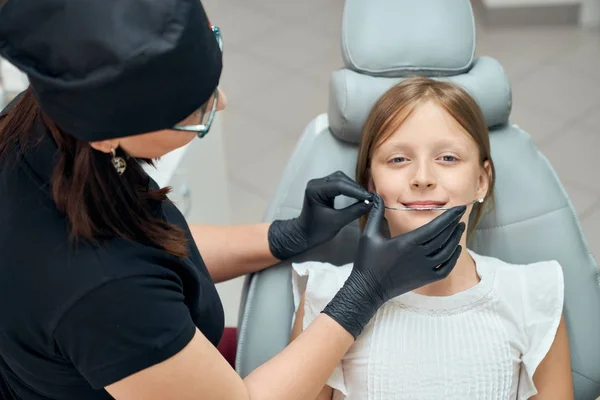 Dokter gigi wanita memperbaiki kawat gigi untuk gadis kecil — Stok Foto