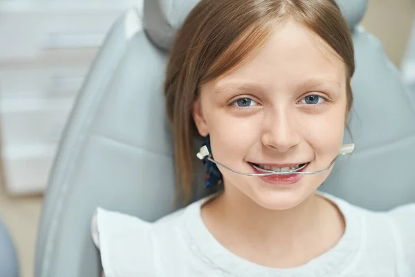 Ragazza felice con apparecchio ortodontico in clinica professionale — Foto Stock
