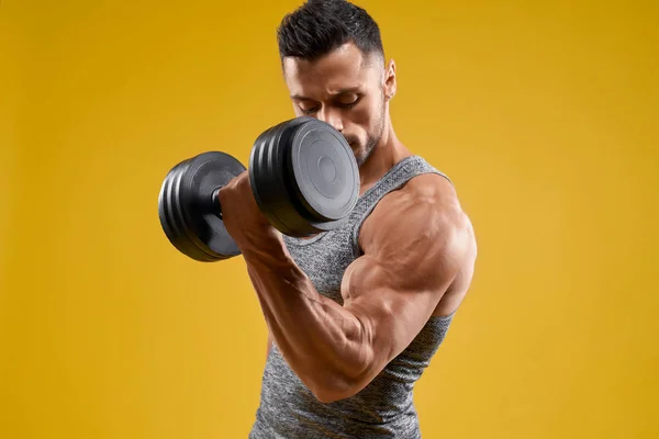 Guapo culturista haciendo ejercicio con mancuerna — Foto de Stock