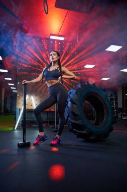 Balyozla poz veren kaslı kadın..