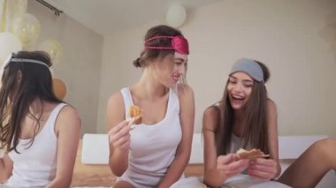 Kapalı alanda pizzayı seven güzel bayanların portresi.