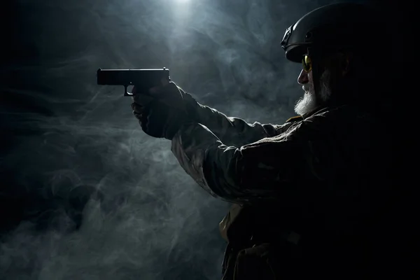 Alter Militäroffizier zeigt mit Waffe. — Stockfoto
