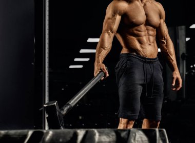 Balyoz tutan kılık değiştirmiş üstsüz bir adam..