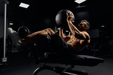 Yedekte topla karın kaslarını çalıştıran adam..