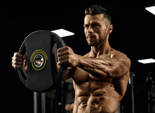 Närbild av bodybuilder håller vikter rakt ut. — Stockfoto