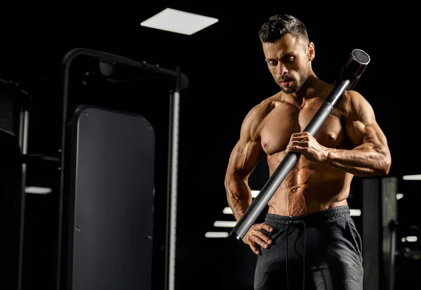 Muskulös kroppsbyggare håller slägga på axeln. — Stockfoto