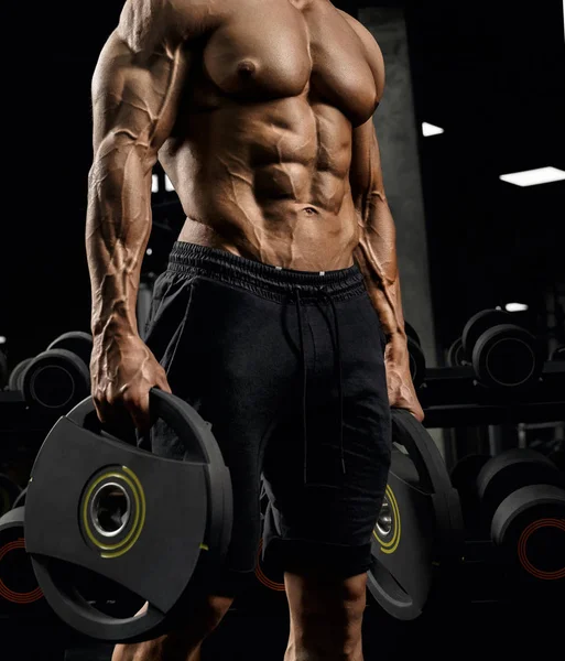 Incognito shirtless bodybuilder holding weights. — Stock Photo, Image