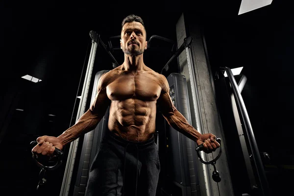 Muskulöser Bodybuilder macht Crossover-Brustgymnastik. — Stockfoto