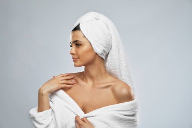 Duştan sonra bornozlu, gülümseyen kadın..