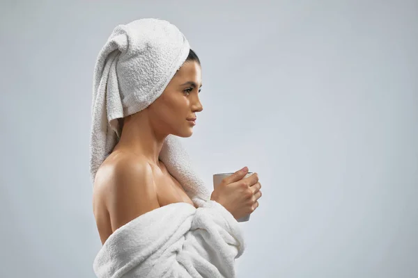 Žena v županu a ručník pití ranní kávu. — Stock fotografie