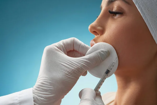 Cosmetoloog die injectiespuit gebruikt om vrouwelijk gezicht te corrigeren. — Stockfoto