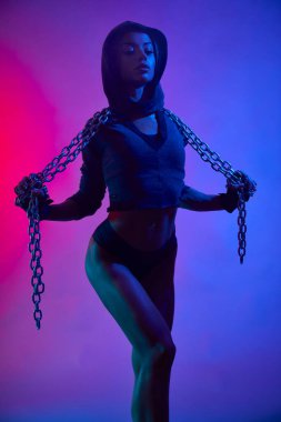 Spor kıyafetli kaslı kız zincir tutuyor..