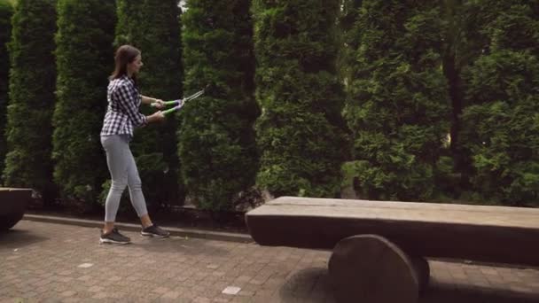 Gelukkig meisje in geruite shirt snoeien heg met de hand schaar — Stockvideo