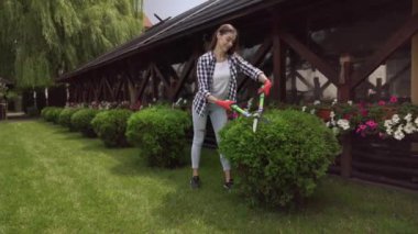 Profesyonel bahçıvan yeşil çalıları makasla kesiyor.