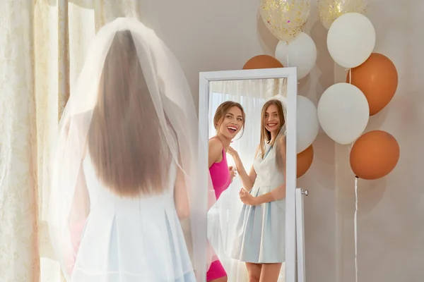 Sorridente sposa e sposa cameriera guardando specchio . — Foto Stock