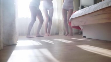Beyaz iç çamaşırlı kızlar peçe takıyor, dans ediyor ve dinleniyorlar.