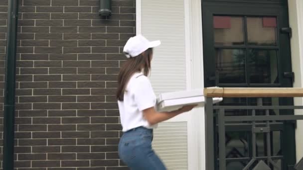 Smiling deliverywoman carrying boxes of pizza. — Stock Video