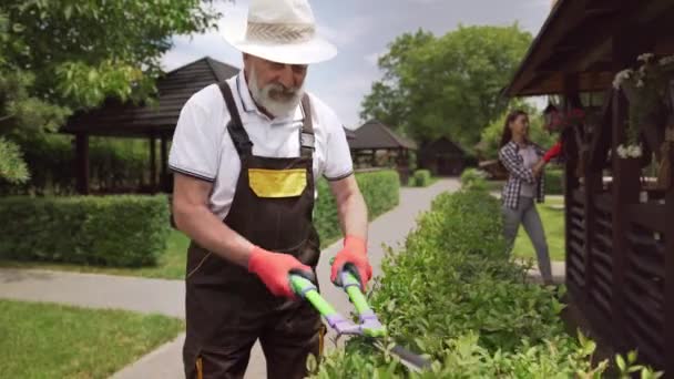 Ανώτερος άντρας και νεαρή κοπέλα κάνουν κηπουρική στην ύπαιθρο — Αρχείο Βίντεο