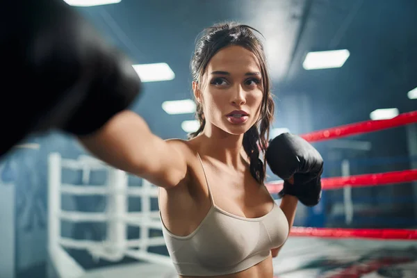 Woman showing hit in boxing gloves. — Stock Photo, Image