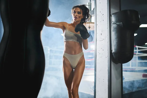 Female boxer hitting punching bag. — Stock Photo, Image