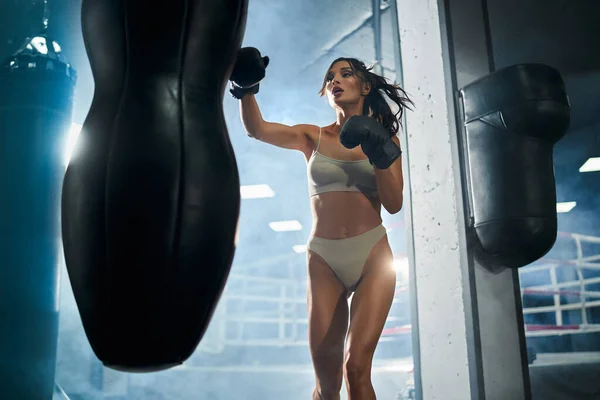 Female boxer hitting punching bag. — Stock Photo, Image