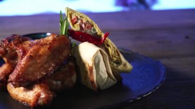 Tavuk kanatları ve sebze ruloları tabakta..