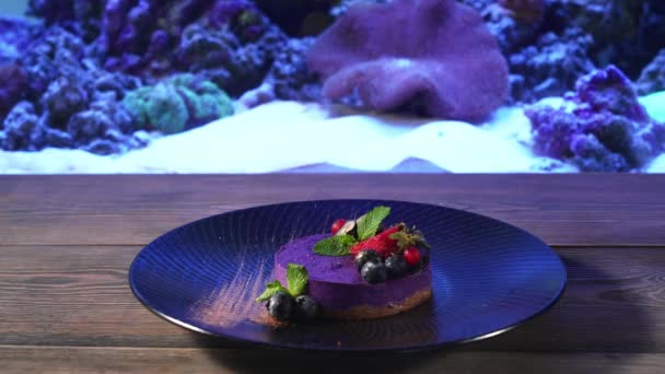 Фиолетовый чизкейк с ягодами на тарелке. — стоковое видео