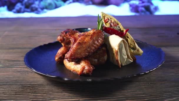 Rolls και ψητά φτερά κοτόπουλου στο πιάτο. — Αρχείο Βίντεο
