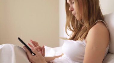 Uyandıktan sonra akıllı telefon kullanan kız.