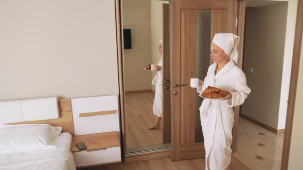 Mujer llevando croissants y taza de bebida caliente . — Vídeos de Stock