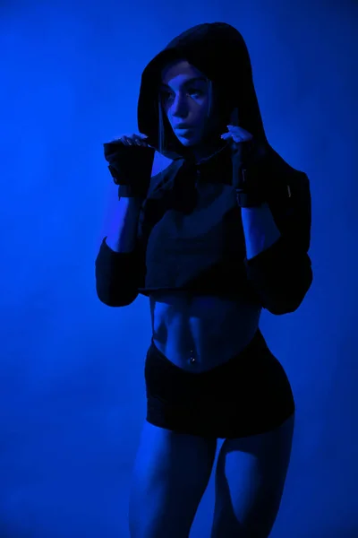 Fit model posing in studio with blue light. — Stock Photo, Image