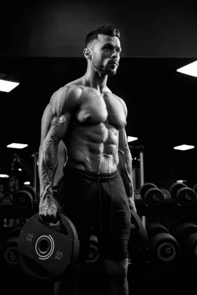 Portrait monochrome de bodybuilder tenant des poids . — Photo
