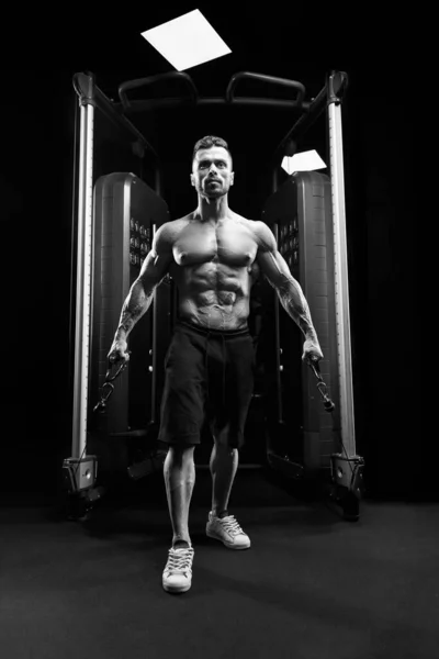 Muskulöser Bodybuilder macht Low-Cable-Crossover-Übung. — Stockfoto