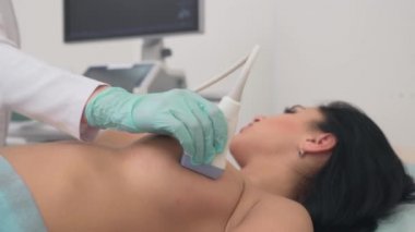 Doktor göğsünü incelemek için ultrason cihazı kullanıyor..