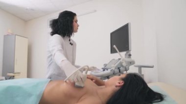 Mammolog göğsü ultrason cihazıyla inceliyor..