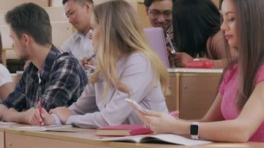 Groupmates sitting at casde desks in university.